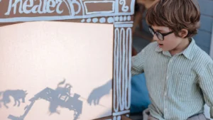Enfant jouant avec des ombres derrière un rideau