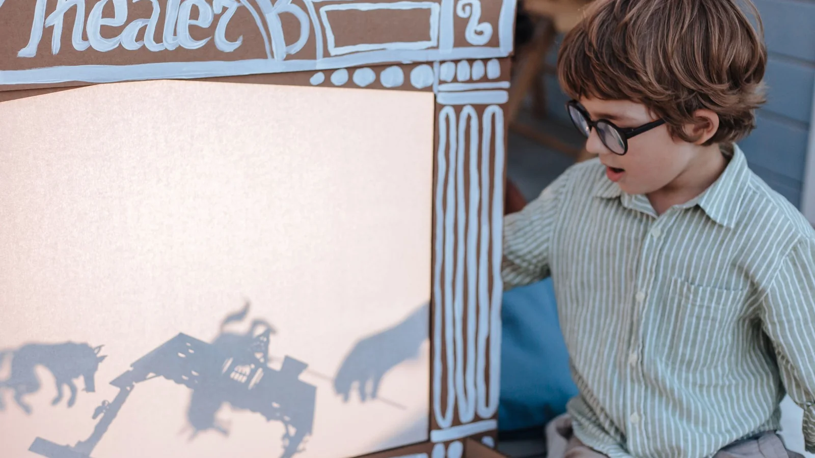 Enfant jouant avec des ombres derrière un rideau